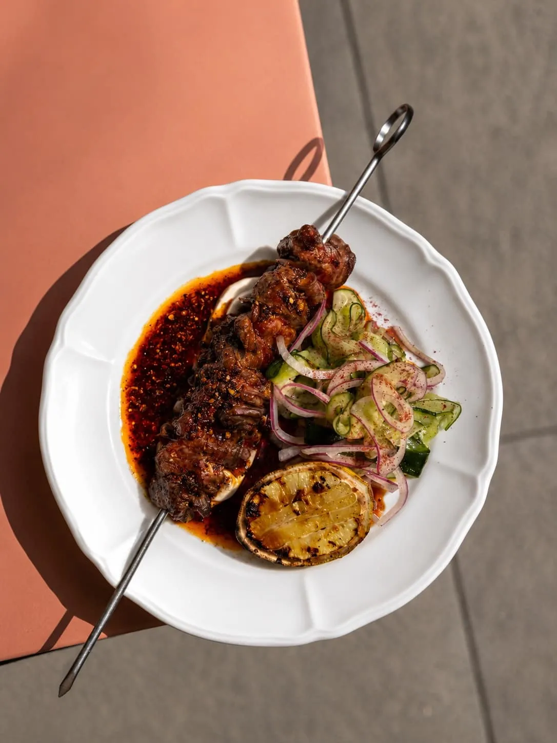 Brochette d'onglet de boeuf sur chili crunch, salade de concombre et citron grillé